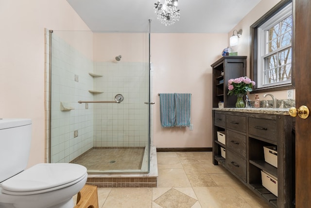 bathroom featuring vanity, a shower with shower door, and toilet