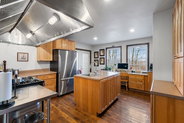 kitchen featuring sink, stainless steel fridge, a kitchen island with sink, range hood, and dark hardwood / wood-style flooring