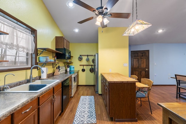 kitchen with lofted ceiling, sink, a center island, pendant lighting, and black appliances