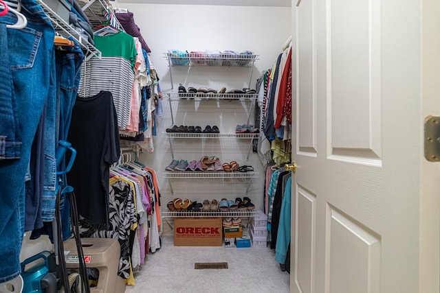 walk in closet with carpet flooring