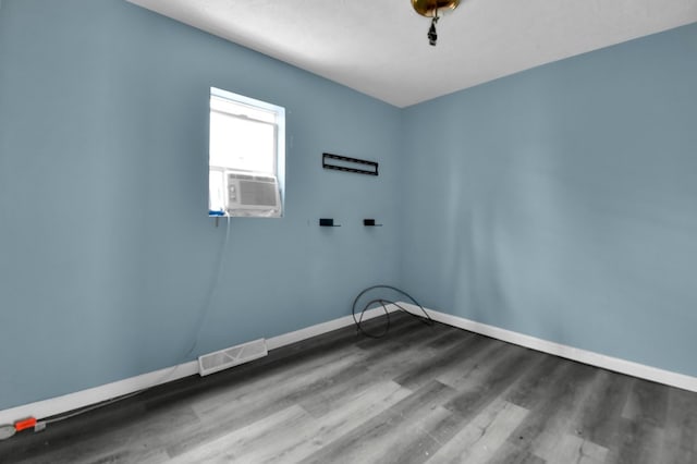 laundry room featuring cooling unit and hardwood / wood-style flooring