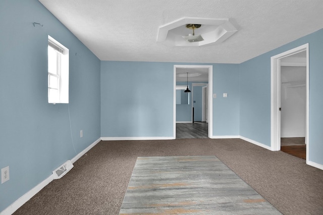 carpeted empty room with a textured ceiling