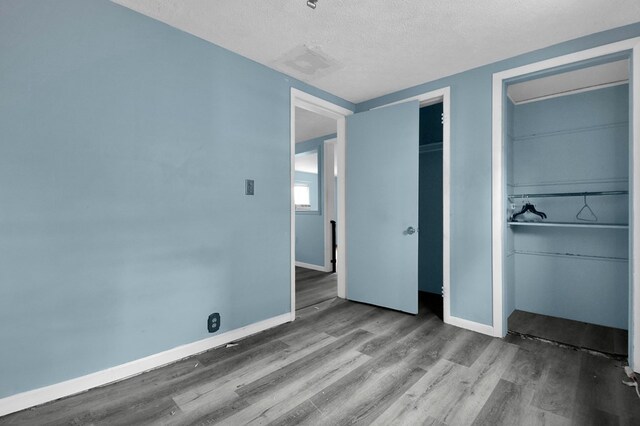 unfurnished bedroom featuring a textured ceiling and hardwood / wood-style flooring