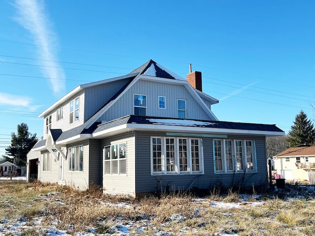 view of snow covered rear of property