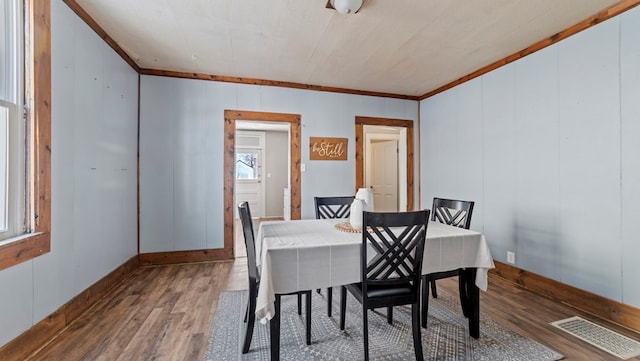 dining area featuring hardwood / wood-style flooring and ornamental molding