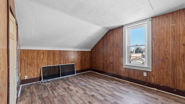 bonus room featuring lofted ceiling, wooden walls, and dark hardwood / wood-style flooring