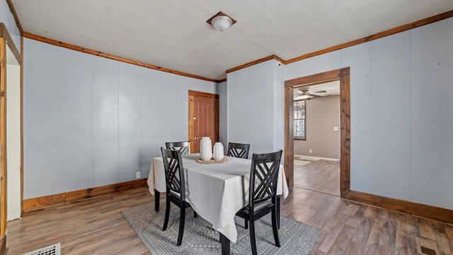 dining space featuring hardwood / wood-style floors and ornamental molding