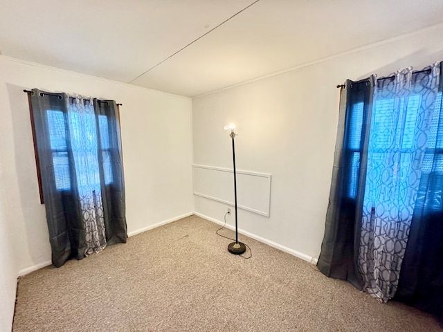 carpeted spare room featuring baseboards