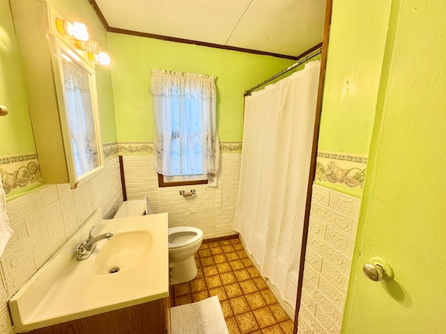 bathroom with a wainscoted wall, toilet, a shower with shower curtain, crown molding, and vanity