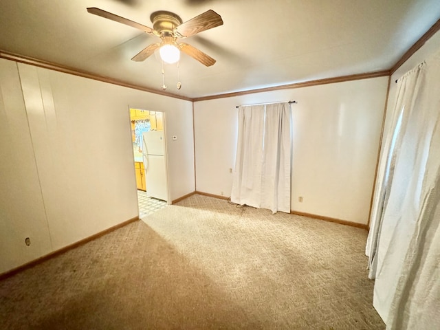 empty room featuring a ceiling fan, baseboards, carpet floors, and ornamental molding