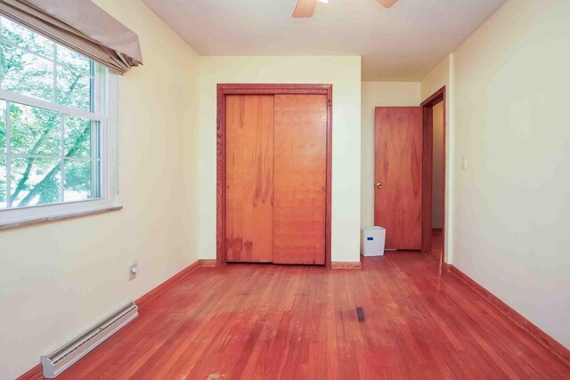 18373 Bentwood Dr, Doylestown, OH 44230 - unfurnished bedroom featuring a baseboard radiator, light wood-type flooring, a ceiling fan, and a closet
