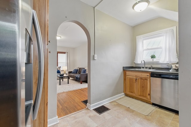 16.5 Monroe Ave, Shelby, OH 44875 - kitchen with stainless steel appliances, a sink, arched walkways, dark countertops, and baseboards