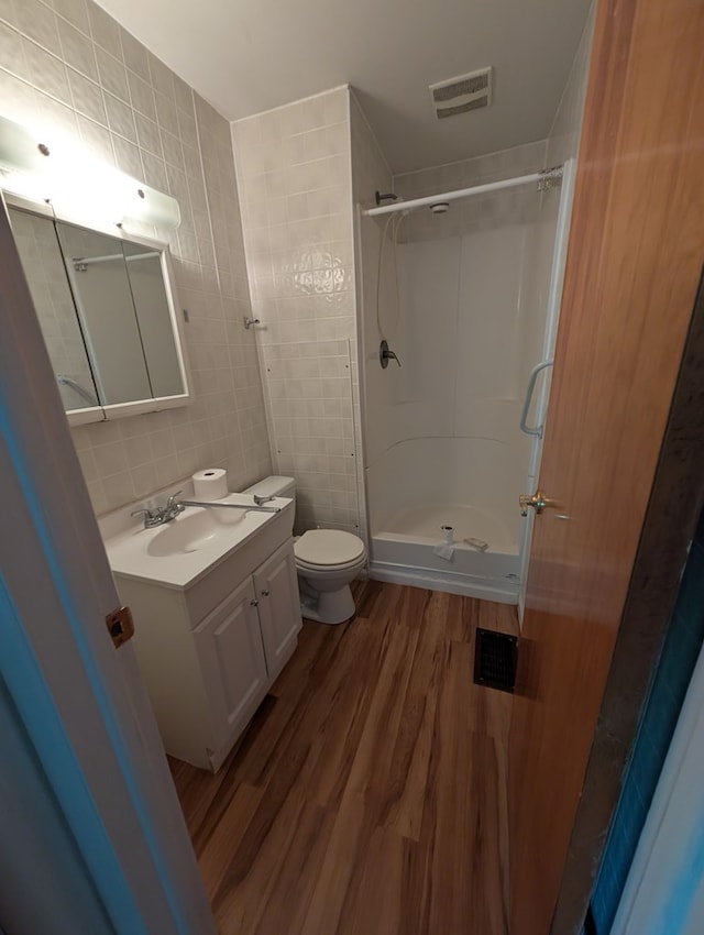 272 Hillside St, Mount Gilead, OH 43338 - bathroom with tile walls, wood finished floors, a shower stall, vanity, and toilet
