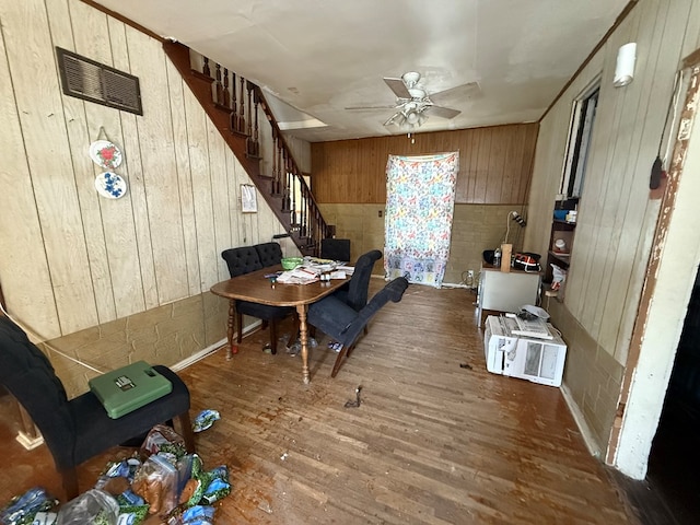 1015 N Cole St, Lima, OH 44805 - dining room featuring wooden walls, ceiling fan, stairs, and wood finished floors