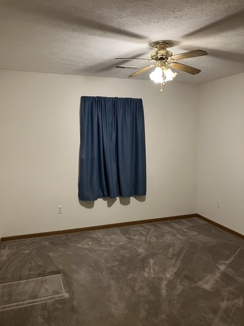 carpeted empty room featuring a textured ceiling and ceiling fan