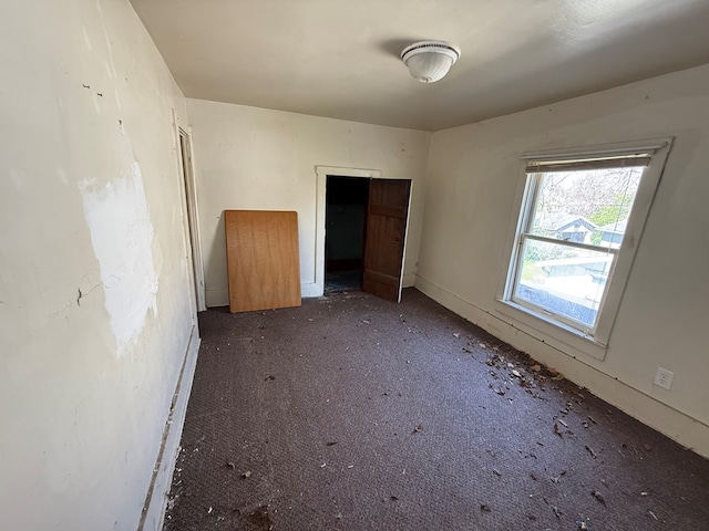 unfurnished bedroom featuring baseboards and carpet
