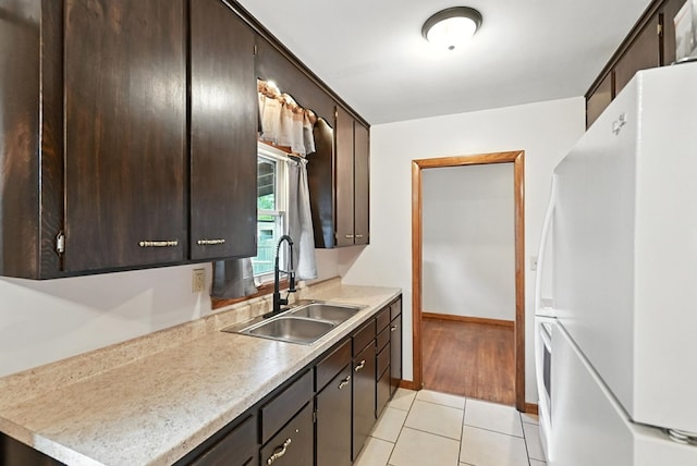 438 Mackey St, Galion, OH 44833 - kitchen with freestanding refrigerator, dark brown cabinetry, and light tile patterned floors
