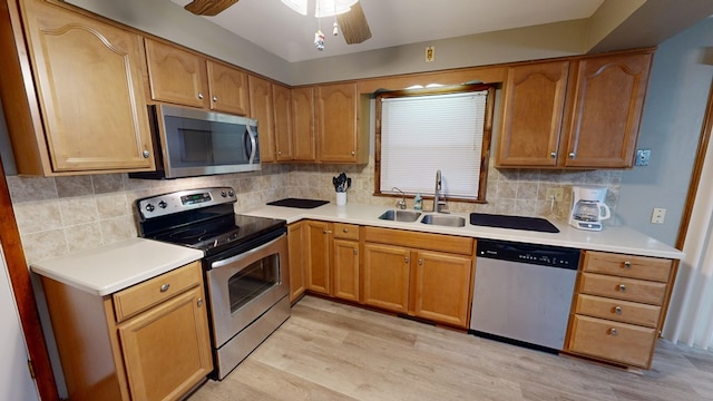 kitchen featuring sink, ceiling fan, stainless steel appliances, decorative backsplash, and light wood-type flooring