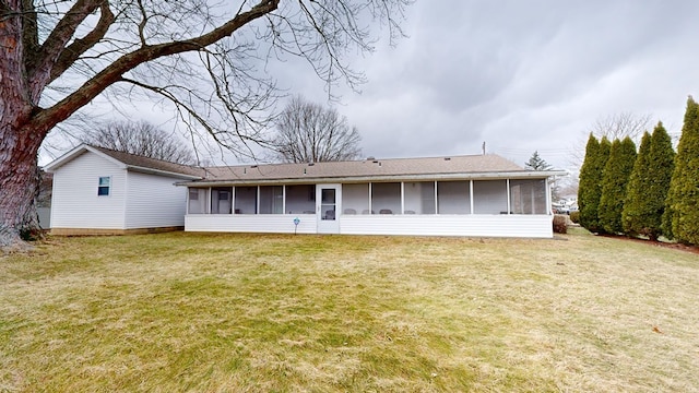 rear view of property featuring a yard and a sunroom