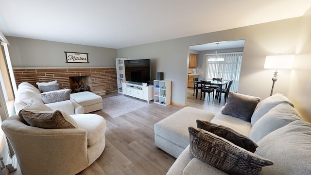 living room with hardwood / wood-style flooring, a chandelier, and a fireplace