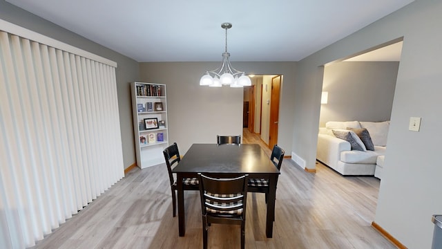 dining space featuring a notable chandelier and light hardwood / wood-style floors