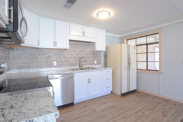 kitchen featuring visible vents, stainless steel appliances, crown molding, and a sink