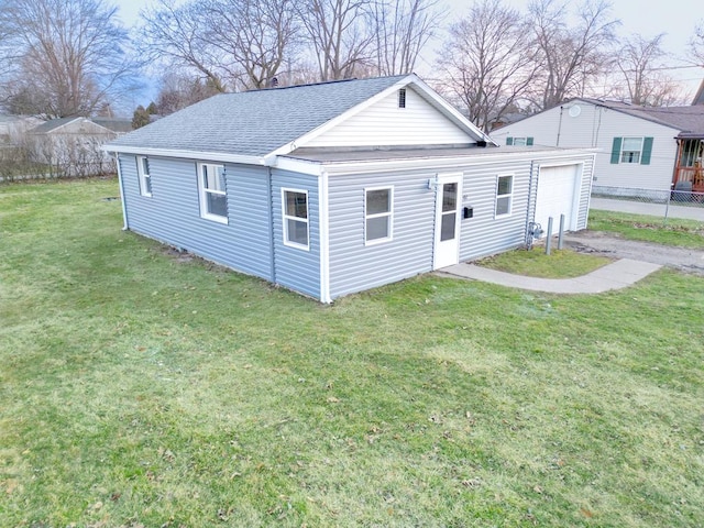 view of front of property with a front yard, fence, aphalt driveway, and a shingled roof