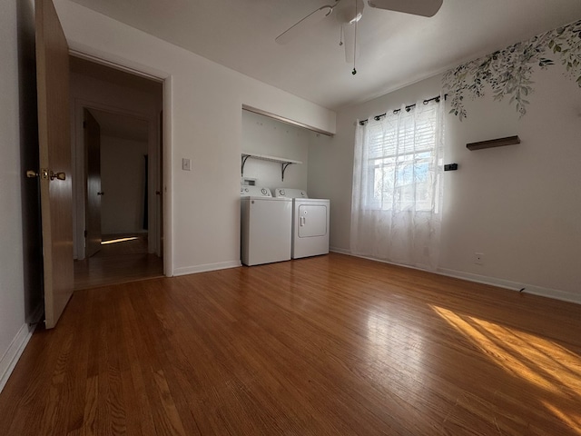 laundry room featuring a ceiling fan, baseboards, washing machine and clothes dryer, and wood finished floors