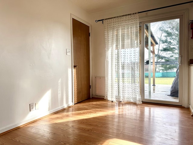 spare room featuring baseboards and hardwood / wood-style floors