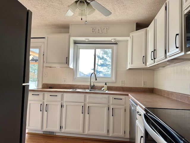 kitchen featuring stainless steel appliances, a sink, and white cabinets