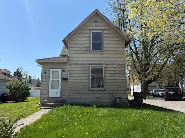 view of front of house featuring entry steps and a front lawn