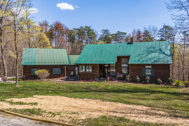 rear view of property featuring a yard and metal roof