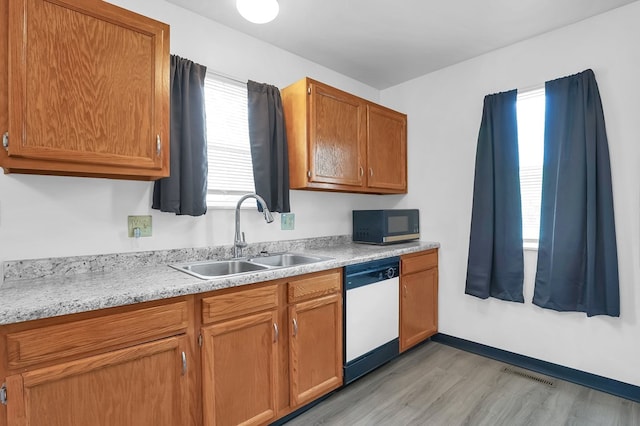 528 N Mulberry St, Street, OH 44902 - kitchen with a sink, dishwasher, light wood finished floors, light countertops, and brown cabinets