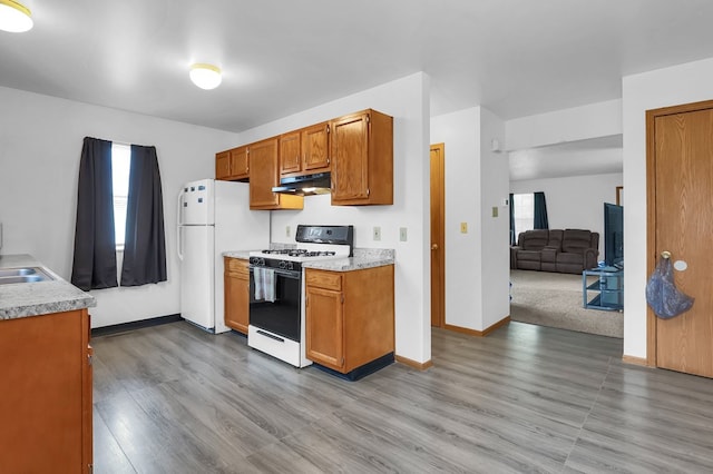 528 N Mulberry St, Street, OH 44902 - kitchen featuring range with gas cooktop, under cabinet range hood, freestanding refrigerator, and light countertops