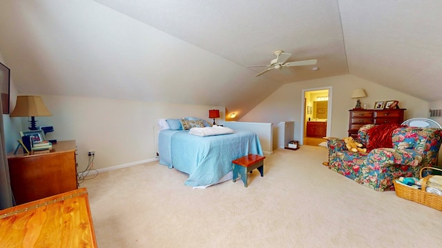 bedroom with ceiling fan, ensuite bathroom, carpet flooring, and vaulted ceiling