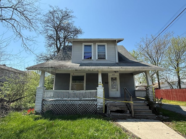 bungalow-style home with covered porch and fence