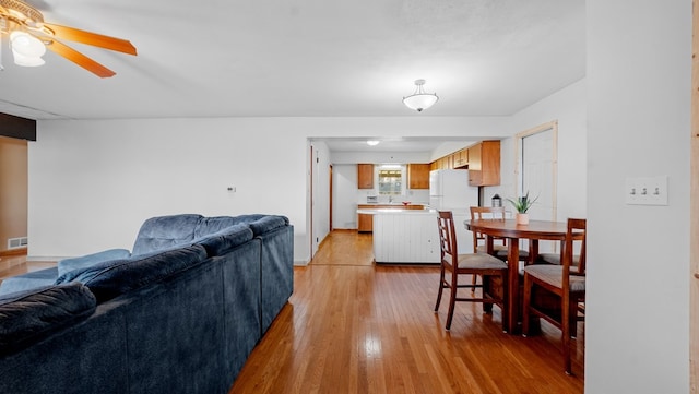 living room featuring light wood-type flooring and ceiling fan