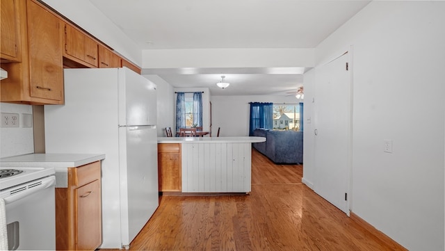 kitchen with kitchen peninsula, ceiling fan, light hardwood / wood-style flooring, and white appliances