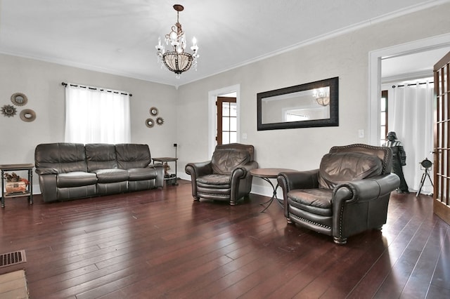 living room featuring dark hardwood / wood-style floors, a healthy amount of sunlight, crown molding, and an inviting chandelier