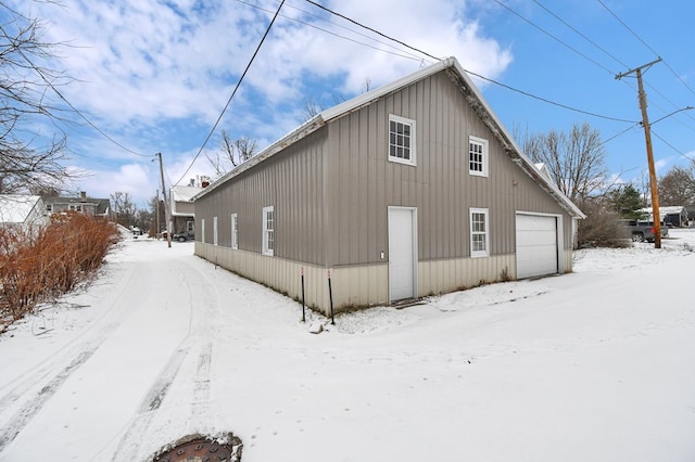 snow covered house featuring a garage