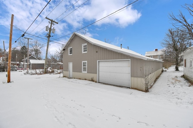 view of snow covered exterior with a garage