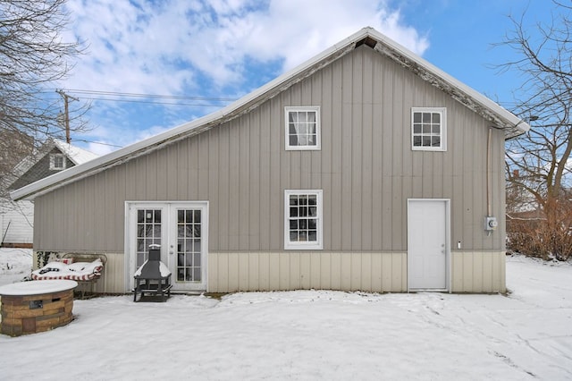 snow covered property with french doors