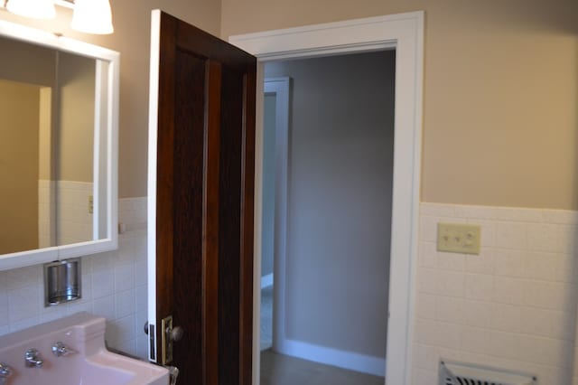 1211 S Sandusky Ave, Bucyrus, OH 44820 - half bathroom with tile walls, wainscoting, and a sink