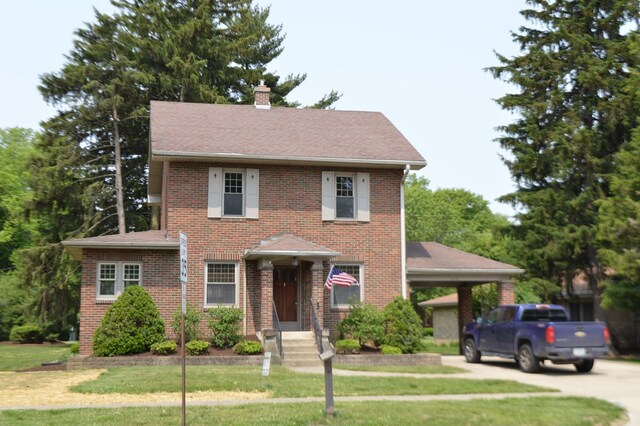 1211 S Sandusky Ave, Bucyrus, OH 44820 - view of front facade with a front yard, a chimney, brick siding, roof with shingles, and concrete driveway