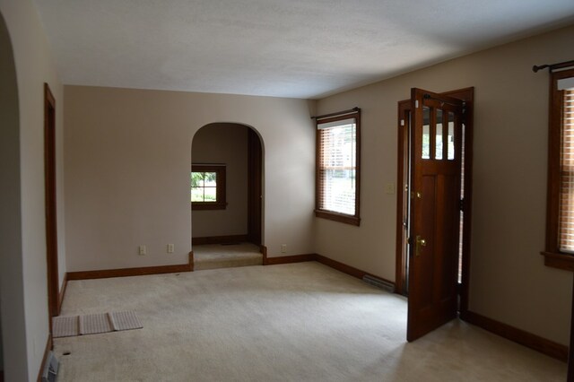 1211 S Sandusky Ave, Bucyrus, OH 44820 - entrance foyer featuring arched walkways, light carpet, and baseboards