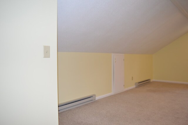 1211 S Sandusky Ave, Bucyrus, OH 44820 - additional living space with a baseboard heating unit, light carpet, vaulted ceiling, and baseboards