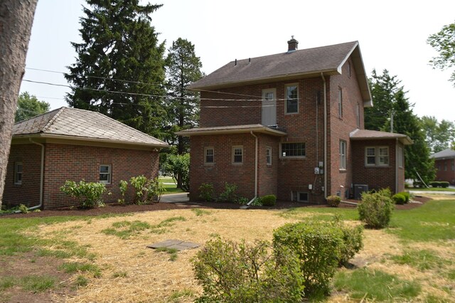 1211 S Sandusky Ave, Bucyrus, OH 44820 - back of house with brick siding, a yard, central AC, and a chimney