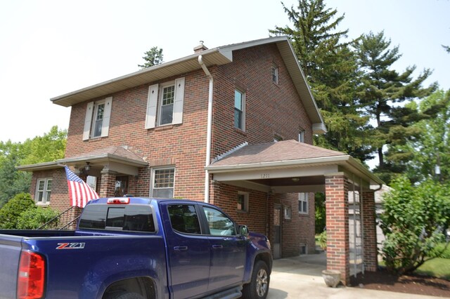 1211 S Sandusky Ave, Bucyrus, OH 44820 - view of front of house featuring brick siding, driveway, a chimney, and an attached carport