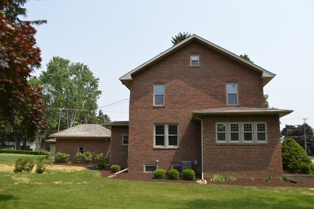1211 S Sandusky Ave, Bucyrus, OH 44820 - back of house with brick siding, a yard, and central AC