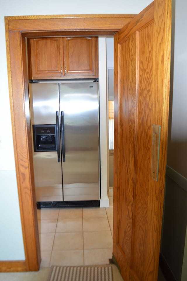 1211 S Sandusky Ave, Bucyrus, OH 44820 - kitchen with stainless steel fridge with ice dispenser, brown cabinetry, and light tile patterned floors